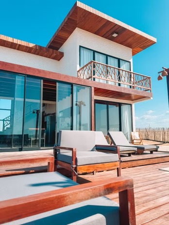 Deck de madeira com espreguiçadeiras de frente para o mar